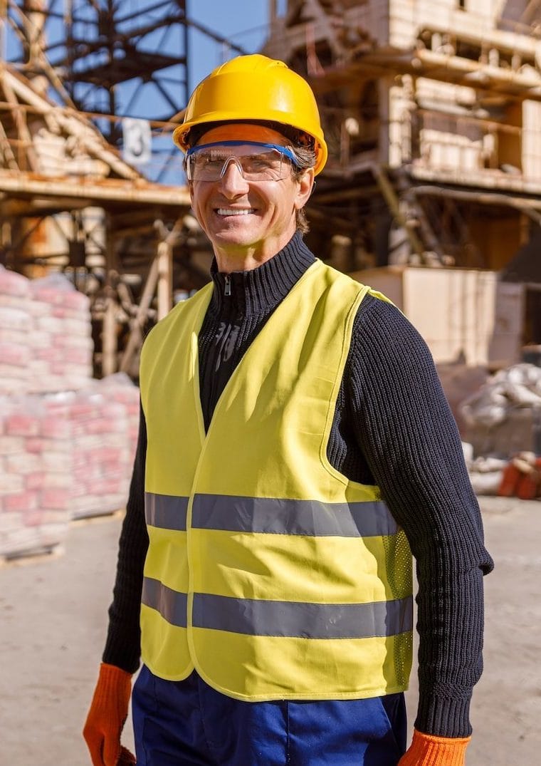 joyful-man-construction-worker-standing-outdoors-at-industrial-site-e1694072989208.jpg